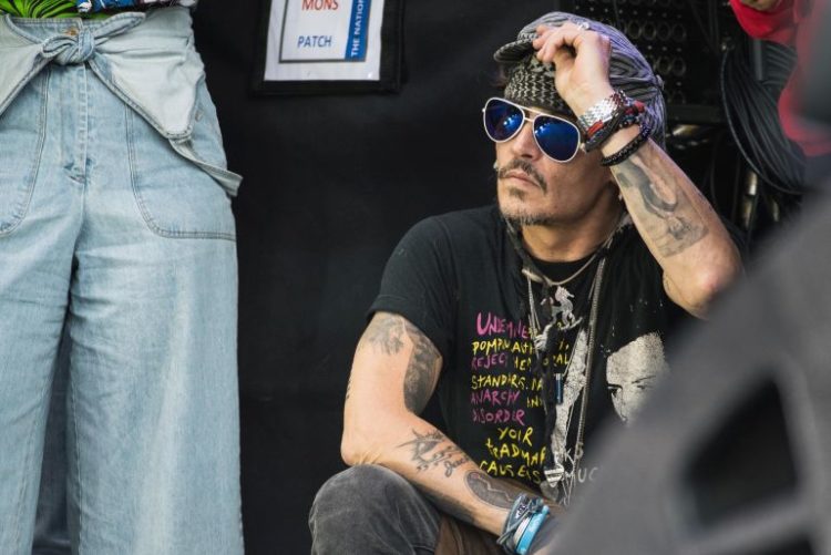 GLASTONBURY, ENGLAND - JUNE 24:  Johnny Depp sits at the side of the Pyramid Stage watching 'Run The Jewels' perform on day 3 of the Glastonbury Festival 2017 at Worthy Farm, Pilton on June 24, 2017 in Glastonbury, England.  (Photo by Ian Gavan/Getty Images)